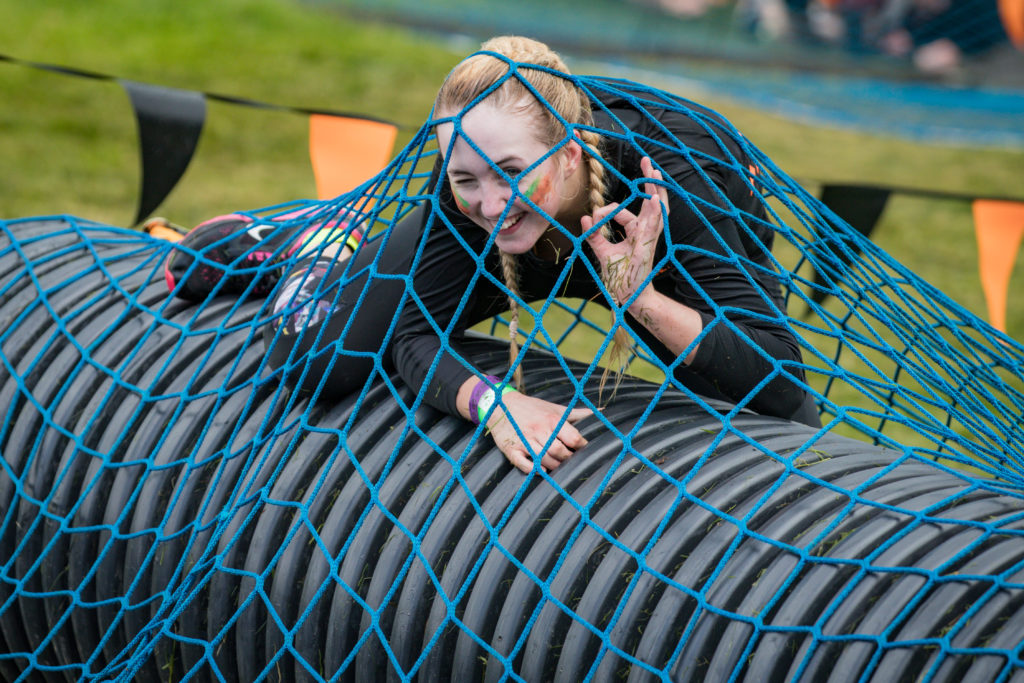 A woman winking from beneath a blue net