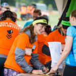Girl in orange top smiling to a participant