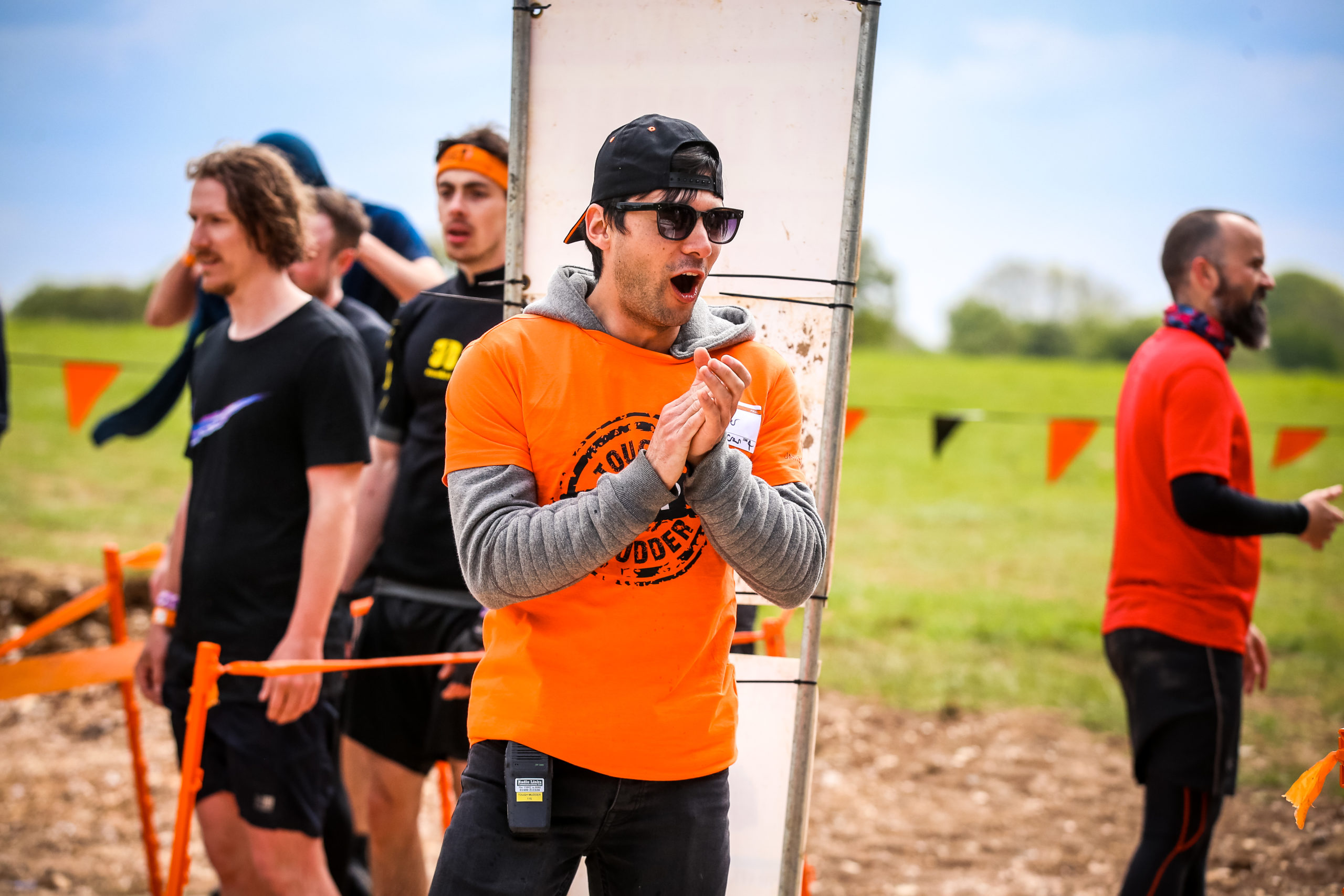Man in orange top clapping in awe