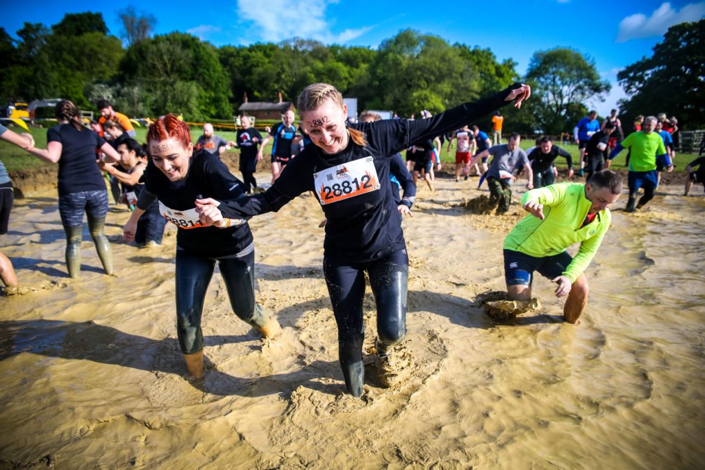 A woman leading lots of people through mud