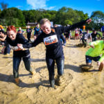 A woman leading lots of people through mud