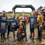 A team taking a picture in the finish line with their muddernation shirts