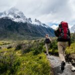 Two people hiking towards mountain